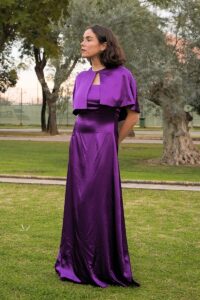 Vestido Palabra de Honor Satén Dorado Largo Petra. Capa Reversible Capelina Corta Morada y Negra Templo Looks de invitada primavera-verano 2025