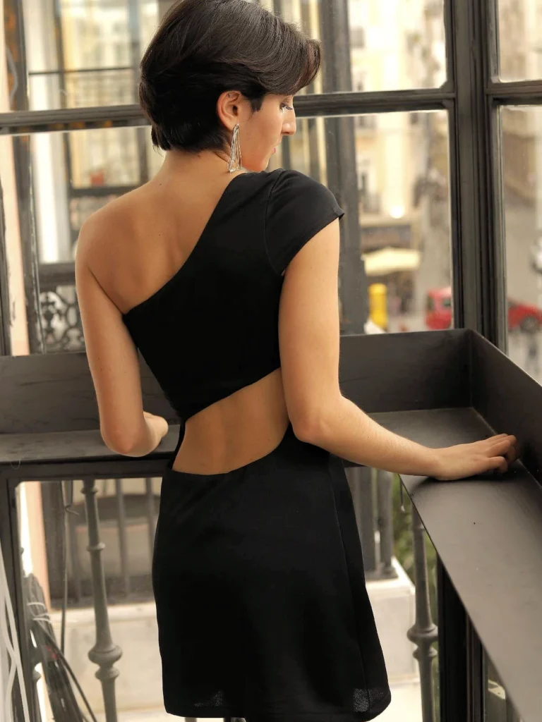 Vestido corto fiesta negro Barbados con diseño asimétrico y espalda cut out. Silueta ajustada y cómoda, ideal para eventos y noches especiales.