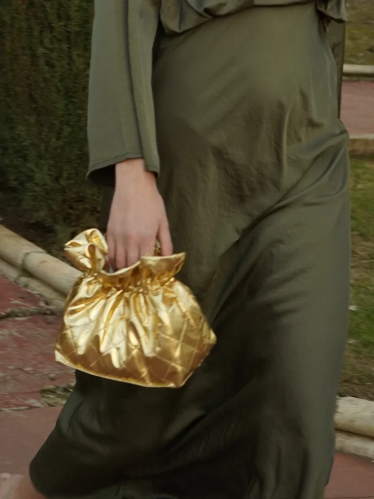 Bolso dorado de fiesta con textura acolchada y acabado metalizado. Elegante, sofisticado y perfecto para bodas y eventos especiales.