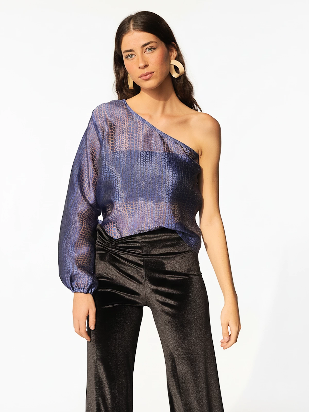 Blusa azul semitransparente asimétrica con manga abullonada en el puño. Diseño ligero y elegante ideal para eventos especiales y looks de noche sofisticados.