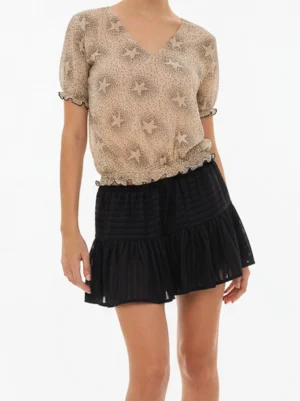 Falda corta negra Hadita con gasa semitransparente y volante. Diseño con volumen y cinturilla elástica, ideal para looks elegantes o casuales.