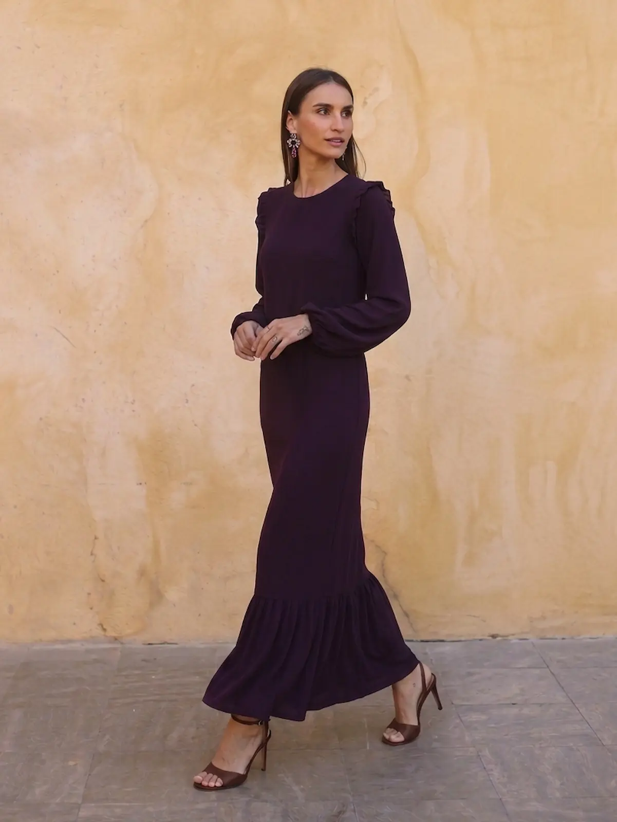 Vestido Largo Berenjena Palma con volantes, tejido fluido y mangas abullonadas. Elegante y favorecedor, ideal para eventos y celebraciones.