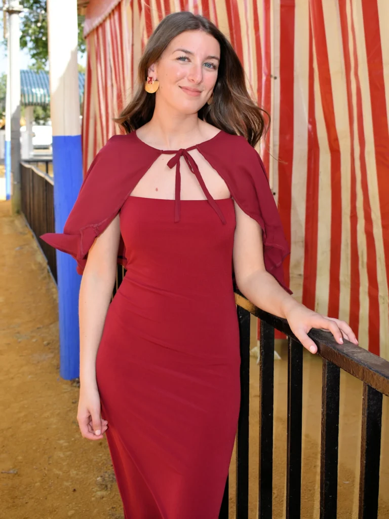 Vestido Burdeos con Capa Invitada Plumas de escote palabra de honor y tejido fluido. Elegante y sofisticado, ideal para bodas y celebraciones.