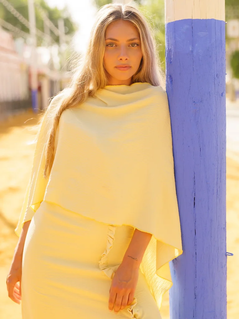 Vestido largo amarillo con capa y espalda descubierta: un diseño luminoso y elegante para invitadas de día y celebraciones.