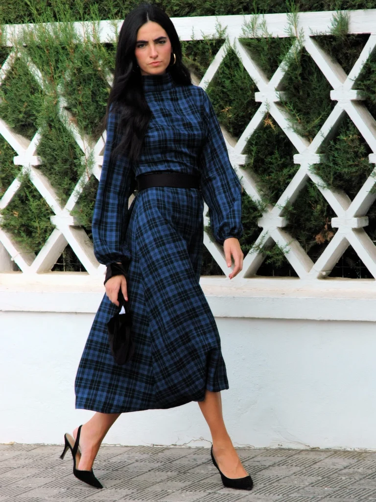 Vestido midi azul escocia de cuadros con cuello alto, mangas largas con volumen y fajín cinturón. Ideal para invitadas y eventos especiales.