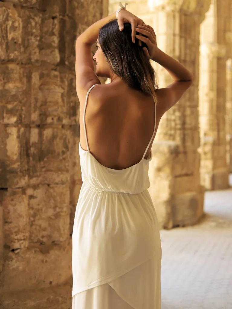 Vestido blanco de tirantes con escote cruzado, cinturón ajustable y falda midi con volantes. Ideal para eventos de día y novia civil | Bombon Spain.
