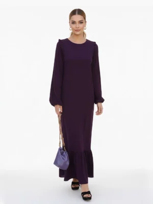 Vestido Largo Berenjena Palma con volantes, tejido fluido y mangas abullonadas. Elegante y favorecedor, ideal para eventos y celebraciones.