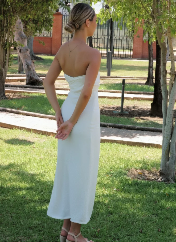Vestido largo blanco con escote drapeado y corte estructurado. Diseño elegante de impacto, confeccionado en España. Ideal para eventos especiales.