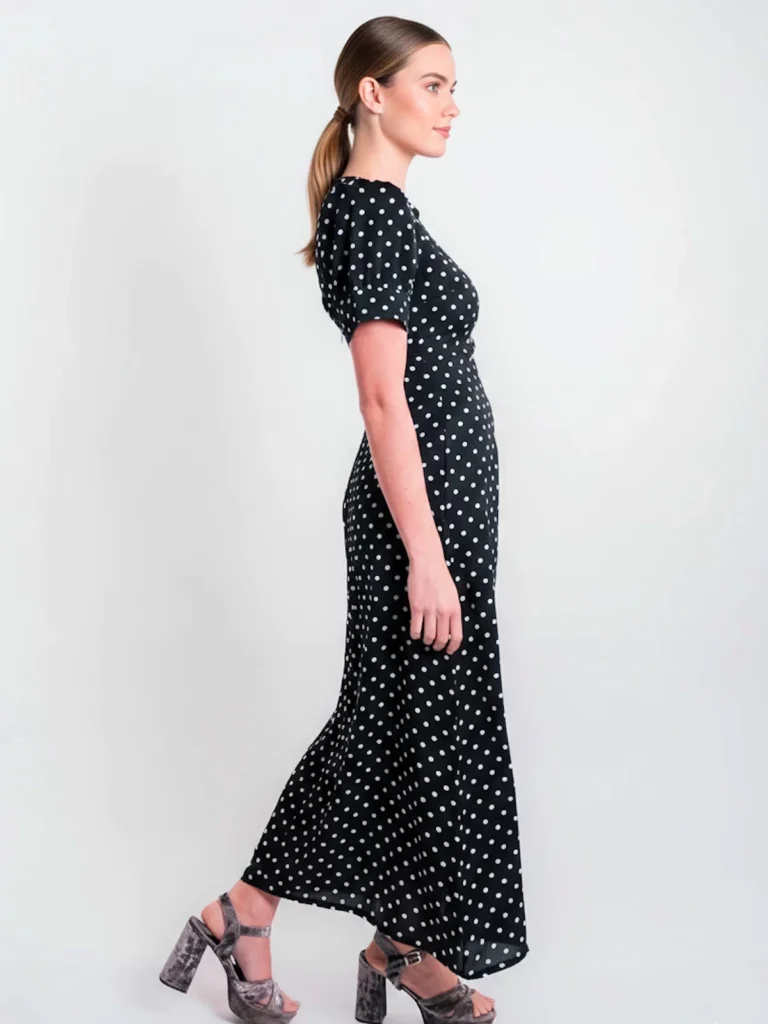 Vestido midi negro de lunares con manga corta y tejido fluido. Diseño atemporal ideal para oficina, eventos y looks diarios elegantes.