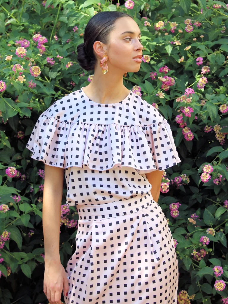 Blusa rosa estampada con volante Miranda. Diseño femenino con tejido satinado y volantes en hombros. Ideal para invitadas, oficina y eventos especiales.