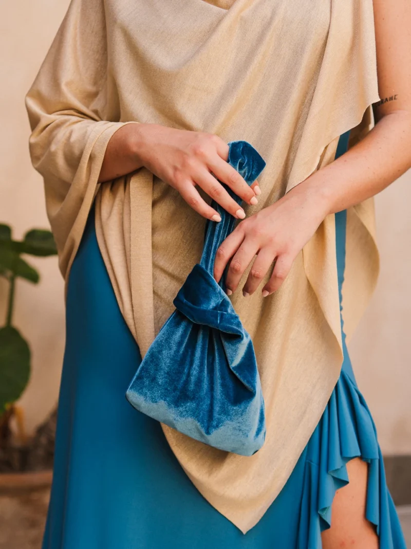La Capa Dorada de Punto es un complemento elegante y sofisticado, perfecto para aportar un toque luminoso y especial a cualquier look de invitada.