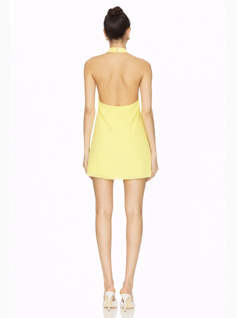 Vestido Corto Amarillo Perla en punto de seda con cuello halter y espalda baja. Diseño ligero, femenino y elegante para eventos.