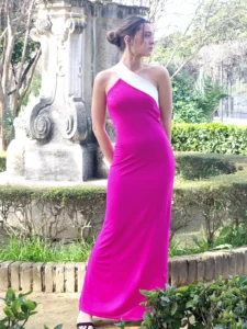 El Vestido Largo Nerea confeccionado en punto con escote asimétrico halter y adorno en otro color, ajustado al cuerpo y espalda baja.