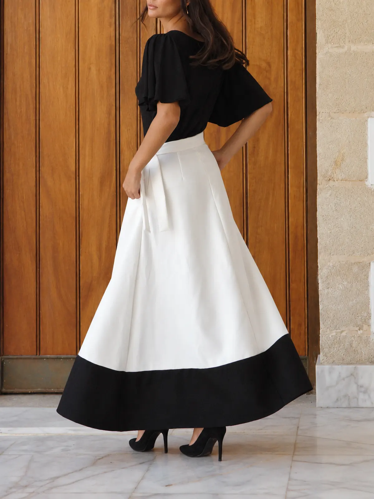 Falda larga estampada con vuelo, cintura en V, lazo y bolsillo. Tonos beige, blanco y negro para looks de invitada elegantes, cómodos y con mucho movimiento