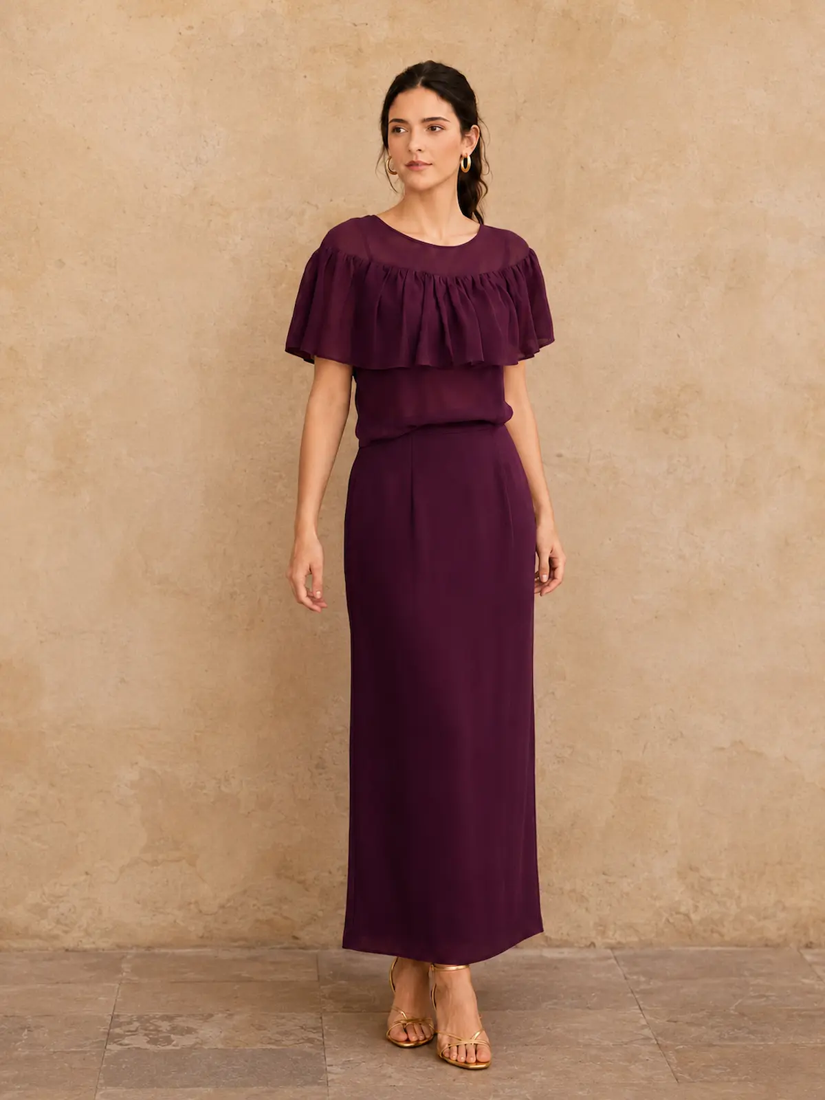 Conjunto elegante y atemporal en color berenjena, con blusa de gran volante y falda midi estructurada con pinzas que realza la figura. Confeccionado en crepé georgette de aspecto ligero y vaporoso.