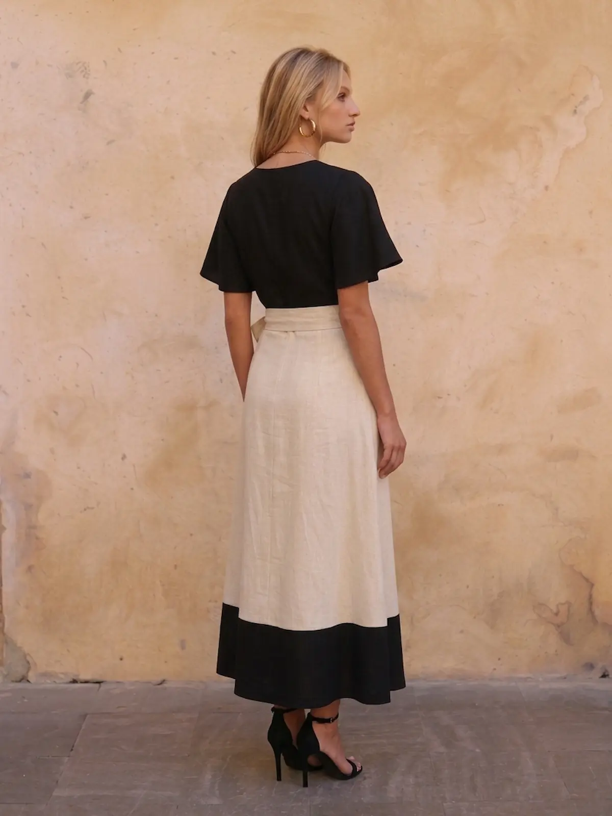Falda larga estampada con vuelo, cintura en V, lazo y bolsillo. Tonos beige, blanco y negro para looks de invitada elegantes, cómodos y con mucho movimiento