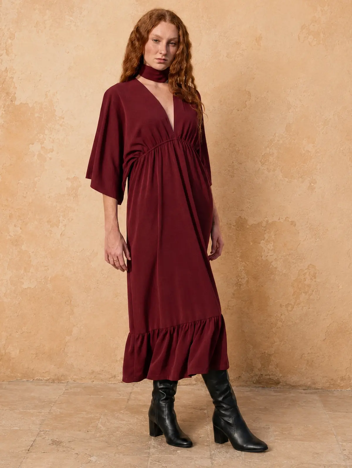 Vestido midi burdeos con un escote pico y tejido fluido. Ideal para eventos y ocasiones especiales con un estilo elegante.