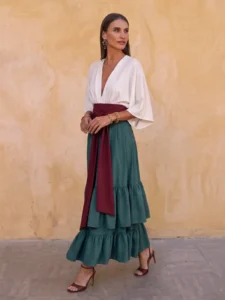 Vestido midi verde Elmar con cuerpo marfil, fajín burdeos y falda de volantes. Un diseño elegante para bodas, graduaciones y eventos.
