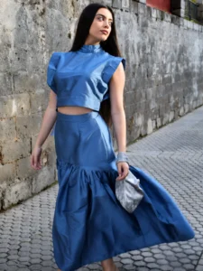 Conjunto azul Cutú con top corto de cuello alto y falda larga con volante. Un diseño elegante y estructurado para eventos y ocasiones especiales.