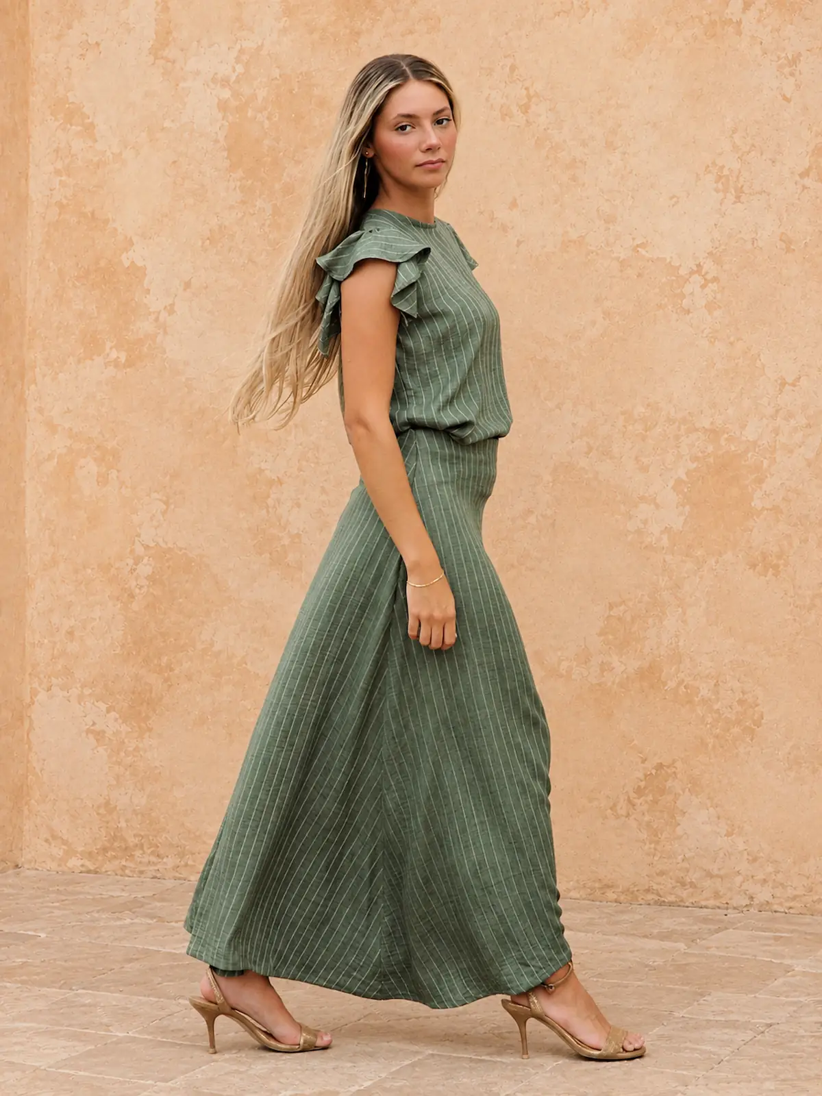 Conjunto verde de rayas Elvis con blusa de doble volante y falda larga asimétrica. Un diseño femenino, fluido y versátil para eventos.