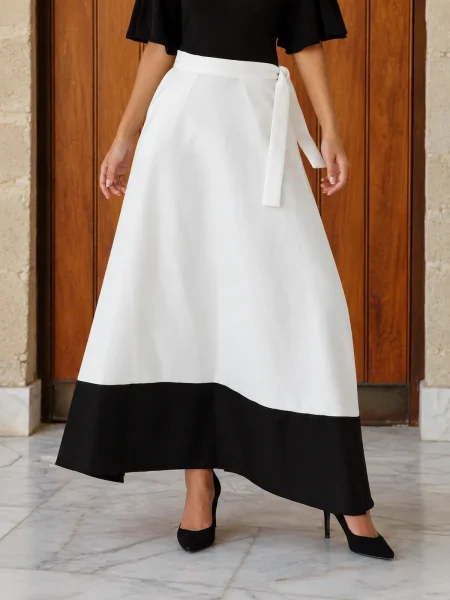 Falda larga estampada con vuelo, cintura en V, lazo y bolsillo. Tonos beige, blanco y negro para looks de invitada elegantes, cómodos y con mucho movimiento