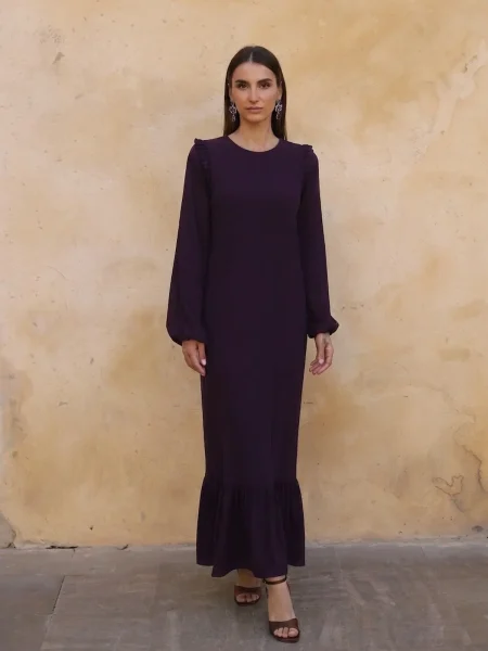 Vestido Largo Berenjena Palma con volantes, tejido fluido y mangas abullonadas. Elegante y favorecedor, ideal para eventos y celebraciones.